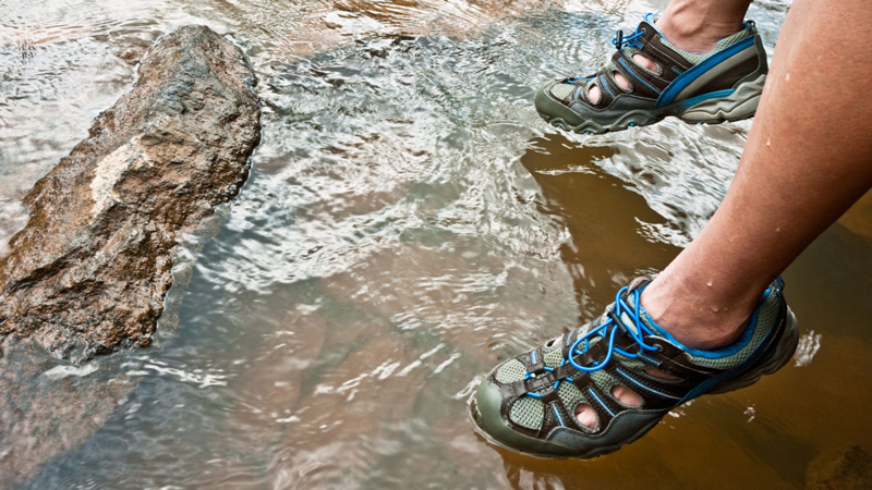 Man wearing sandals by river